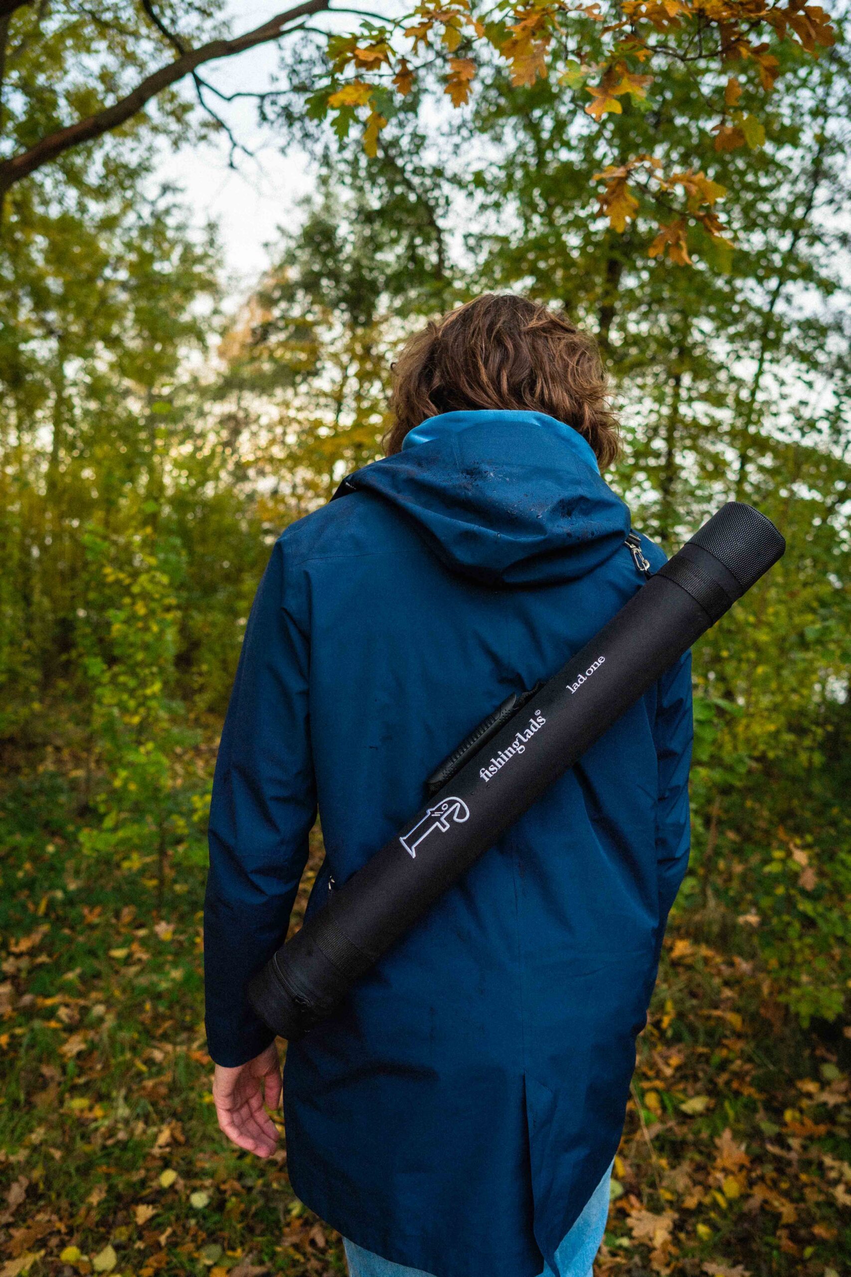 Person trägt die lad one® Angel Reiserute im Transportrohr auf dem Rücken beim Spaziergang im Wald